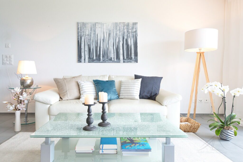 Musterwohnung weisse Ledersofa mit glas Beistelltische, kissen in weiss ud blau